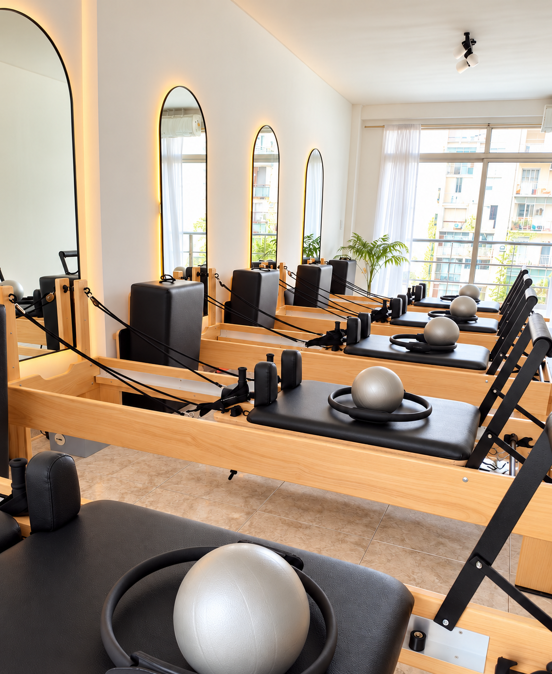 Estudio Thais Reformer en Arce, con reformers de madera y espejos iluminados